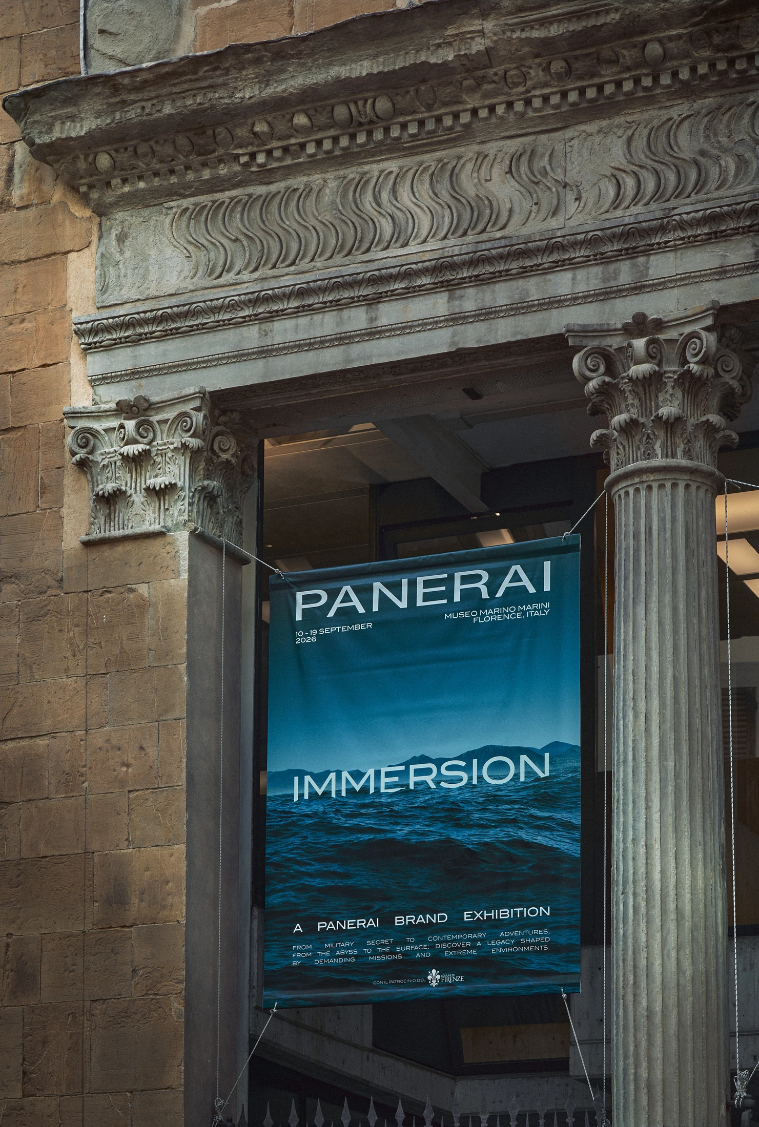Immersion exhibition poster displayed between the stone columns at the entrance to Museo Marino Marini, Florence.