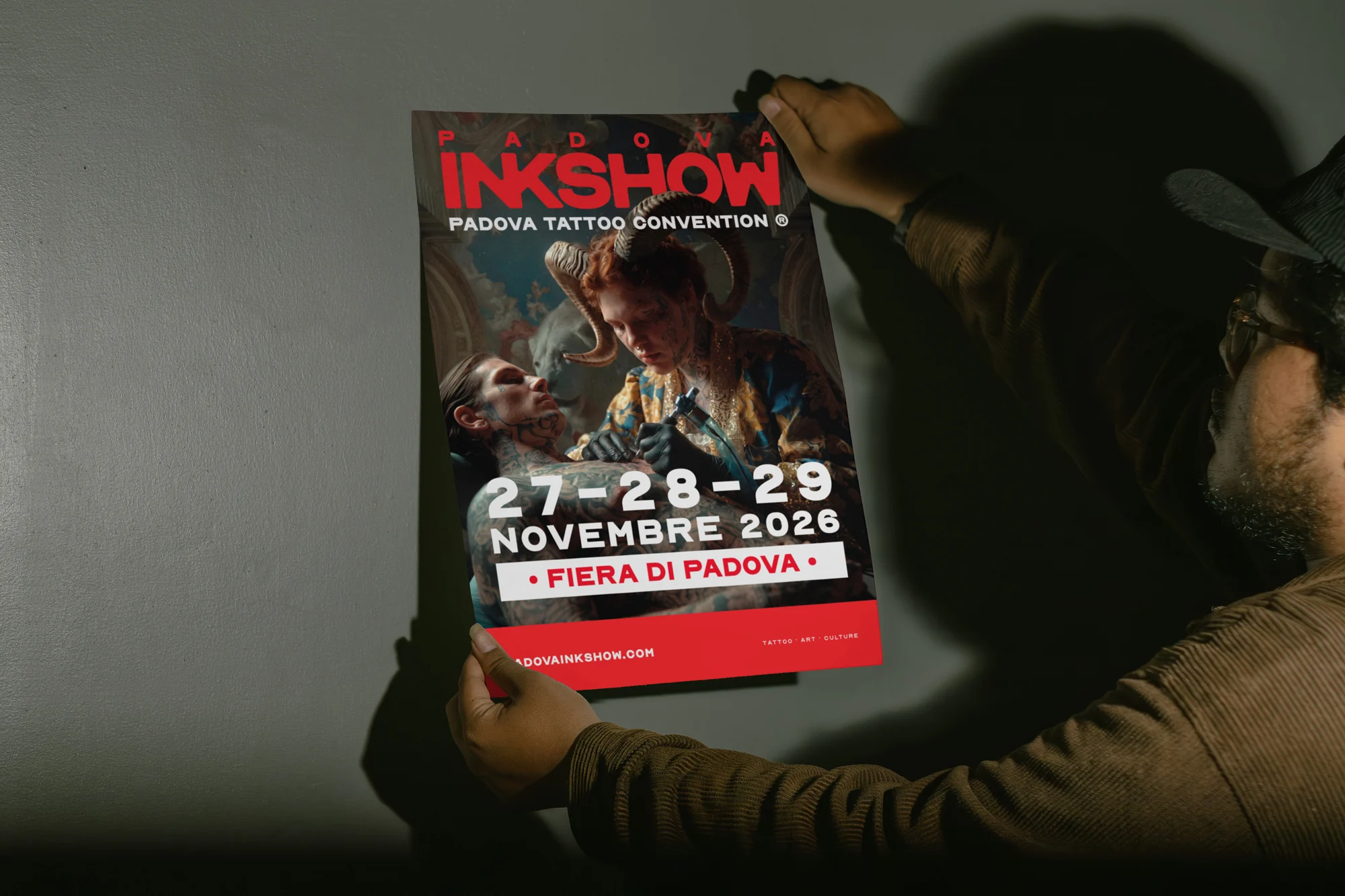 InkShow event poster being placed on a wall